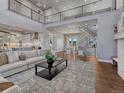 Spacious living area features a large rug, modern furnishings, and an open-concept design leading to the kitchen at 2690 Fox View Trl, Franktown, CO 80116