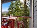 Inviting balcony with a red metal table and chairs and with scenic views of the lush greenery at 100 S Park Ave # E321, Breckenridge, CO 80424