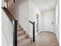 Bright entryway featuring a staircase with black and white railings and luxury vinyl flooring at 9992 Racine St, Commerce City, CO 80022