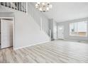 Spacious and bright living room with light wood floors, a white staircase, and natural light at 1551 Northridge Dr, Highlands Ranch, CO 80126