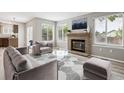 Bright living room with a brick fireplace, large windows, stylish furniture, and contemporary decor at 1551 Northridge Dr, Highlands Ranch, CO 80126