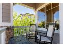 Cozy front porch with rocking chairs and a small table, perfect for relaxing outdoors at 10554 Atwood Cir, Littleton, CO 80130