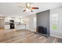 Bright living room featuring a brick fireplace, ceiling fan, and modern vinyl flooring at 15440 E Oberlin Pl, Aurora, CO 80013