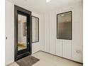 Bright entryway features black trimmed windows, white walls, and a modern black front door at 39417 Stockton Cir, Elizabeth, CO 80107