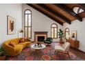 Bright living room featuring vaulted ceilings, wood beams, fireplace, and large windows showcasing natural light at 6 Martin Ln, Englewood, CO 80113