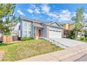 Charming two-story home with blue siding, well-manicured front yard, and two-car garage at 12388 Jasmine St, Brighton, CO 80602