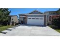 Attractive home featuring gray siding, a two-car garage, concrete driveway, and manicured lawn at 12388 Jasmine St, Brighton, CO 80602
