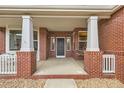 Charming front porch with brick columns and cozy swing, offering a welcoming entrance to the home at 17979 E Dorado Dr, Centennial, CO 80015