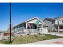 Exterior view of a blue home, featuring a landscaped yard and charming front porch at 965 Peach Leaf Ln, Elizabeth, CO 80107