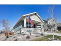 Inviting front porch with American flag, stone pillars, and seating at 965 Peach Leaf Ln, Elizabeth, CO 80107