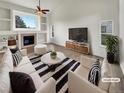 Bright living room features a fireplace, built-in shelves, and stylish decor, virtually staged at 5521 Spruce Ave, Castle Rock, CO 80104