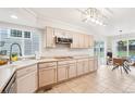 Bright kitchen featuring beige cabinets, stainless appliances, and tile flooring adjacent to dining area at 5129 Pasadena Way, Broomfield, CO 80023