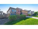 Charming exterior view of a home with lush green lawn and an American flag at 6932 E 133Rd Ave, Thornton, CO 80602