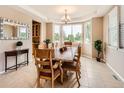 Bright dining room with large windows, tray ceiling, and a wooden table set for six at 8522 S Dudley St, Littleton, CO 80128