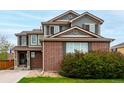 Inviting two-story home featuring brick accents, gray siding, and well-maintained landscaping at 4873 S Fultondale Way, Aurora, CO 80016