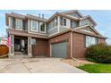 Attractive home featuring brick, gray siding, a two-car garage, and well-maintained landscaping at 4873 S Fultondale Way, Aurora, CO 80016