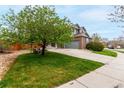 Beautiful home with green lawn, mature tree, spacious driveway, and an attached two-car garage at 4873 S Fultondale Way, Aurora, CO 80016