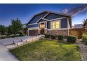 Beautiful home with blue exterior, stone details, a well-manicured lawn, and lighted pathway to front door at 25 N Irvington St, Aurora, CO 80018