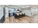 Stylish kitchen with an island, seating, stainless steel appliances, and a modern backsplash at 25 N Irvington St, Aurora, CO 80018