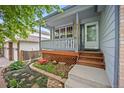 Inviting front porch with decorative railing and landscaped garden at 4982 S Danube St, Aurora, CO 80015