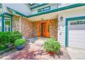 Inviting entryway featuring a stone facade, wood door and well-maintained landscaping at 379 Lincoln Ct, Louisville, CO 80027