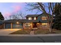 Charming two-story home featuring a brick facade, red shutters, and a well-manicured front yard at 2090 S Gray Dr, Lakewood, CO 80227