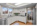Well-lit kitchen offers white cabinetry, granite counters, and access to dining area at 2090 S Gray Dr, Lakewood, CO 80227
