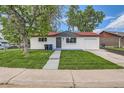 Newly renovated home with mature shade trees and a lush front lawn at 14317 Olmsted Dr, Denver, CO 80239