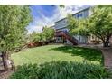 Expansive backyard with a multi-level deck, lush green lawn, and mature trees offering shade at 16671 E Prairie Goat Ave, Parker, CO 80134