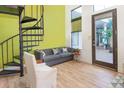 Bright living area features a spiral staircase, modern furniture, light wood floors, and natural light at 1732 Wazee St # 201, Denver, CO 80202