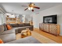 Bright living room with hardwood floors, comfy sectional seating, and modern media console at 4720 W Stanford Ave, Denver, CO 80236