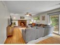 Cozy living room features a brick fireplace, hardwood floors, and sliding glass doors to the backyard at 4720 W Stanford Ave, Denver, CO 80236