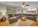 Open-concept living room boasts hardwood floors, a large sectional sofa, and access to the kitchen at 4720 W Stanford Ave, Denver, CO 80236
