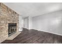 Inviting living room featuring a stone fireplace and modern dark wood flooring at 2927 W 81St Ave # B, Westminster, CO 80031