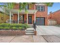 Inviting red brick home with a quaint porch, neat landscaping, and an attached garage at 2436 W Argyle Pl, Denver, CO 80211