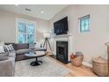 Cozy living room featuring a fireplace, a comfortable gray couch, and natural light from a window at 2436 W Argyle Pl, Denver, CO 80211