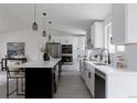 Modern kitchen with a large island, white cabinets, and stainless steel appliances at 8249 Zephyr St, Arvada, CO 80005