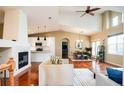 Open-concept living area with vaulted ceilings, fireplace, hardwood floors, and seamless flow to the dining and kitchen at 7777 E 23Rd Ave # 1202, Denver, CO 80238