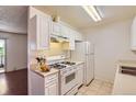Cozy kitchen featuring white cabinets, gas range and tile flooring at 10762 E Exposition Ave # 336, Aurora, CO 80012