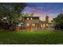 The exterior of the home boasts a sunroom, wood deck, and mature trees and a spacious lawn at 10450 Iris Way, Broomfield, CO 80021
