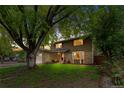 Traditional two-story home with brick and wood siding, a well-manicured lawn, and mature trees at 10450 Iris Way, Broomfield, CO 80021