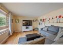 Inviting living room featuring hardwood floors, a large-screen TV, and stylish furnishings at 4855 E Atlantic Pl, Denver, CO 80222