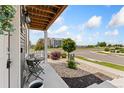 Inviting covered front porch with seating, landscaping, and decorative rocks at 18552 E 54Th Ave, Denver, CO 80249