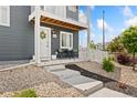 Inviting front porch with seating, a white door with a wreath, and lovely landscaping at 18552 E 54Th Ave, Denver, CO 80249