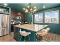Modern kitchen featuring a large island, stainless steel appliances, and stylish gold accents at 18552 E 54Th Ave, Denver, CO 80249