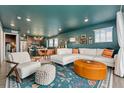 Bright living room with stylish furniture and colorful decor, seamlessly connected to the kitchen at 18552 E 54Th Ave, Denver, CO 80249