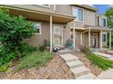 Charming front porch with tasteful landscaping and concrete steps leading to the unit at 1818 S Quebec Way # 4, Denver, CO 80231