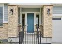 Close up of a stylish front door with stone pillar accents and modern outdoor lighting at 22183 E Rocky Top Pl, Aurora, CO 80016