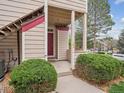Inviting exterior view of a townhome featuring a covered entrance and well-maintained landscaping at 8371 S Upham Way # 103, Littleton, CO 80128