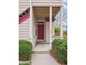 Charming front entrance with a red door, partial porch, and neatly trimmed green shrubs at 8371 S Upham Way # 103, Littleton, CO 80128